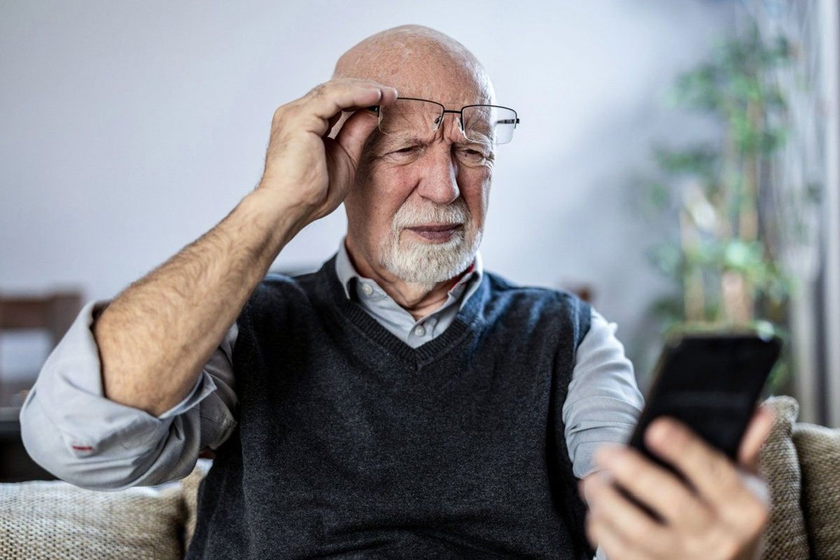 de gepensioneerde houdt de telefoon vast
