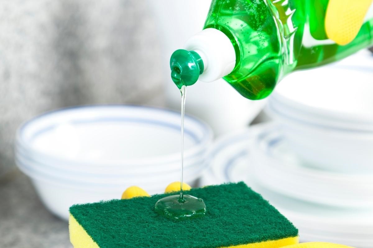 afwasmiddell wordt op een spons gegoten