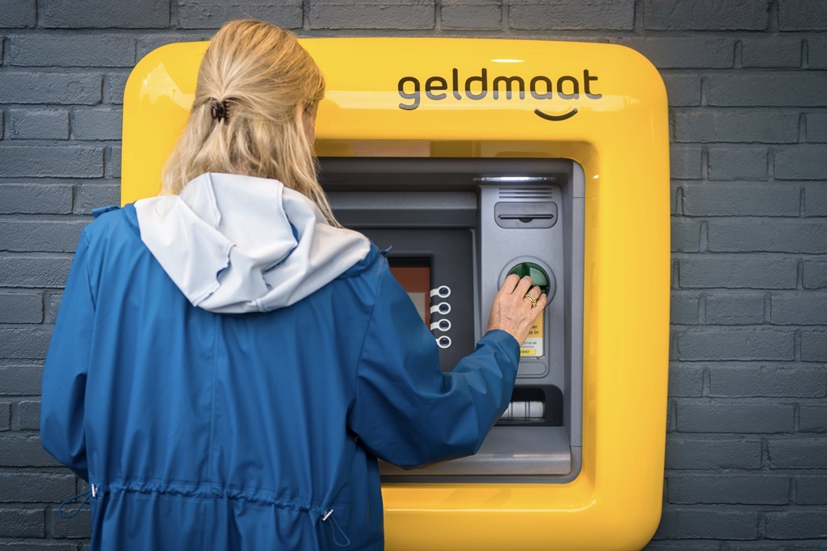 een meisje neemt geld op bij een Geldautomat