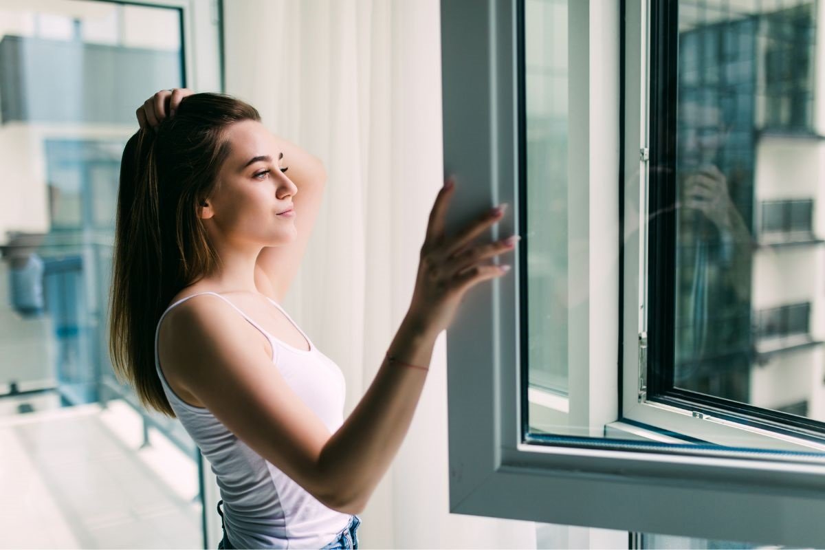 Het meisje ademt frisse lucht in en lucht de kamer.