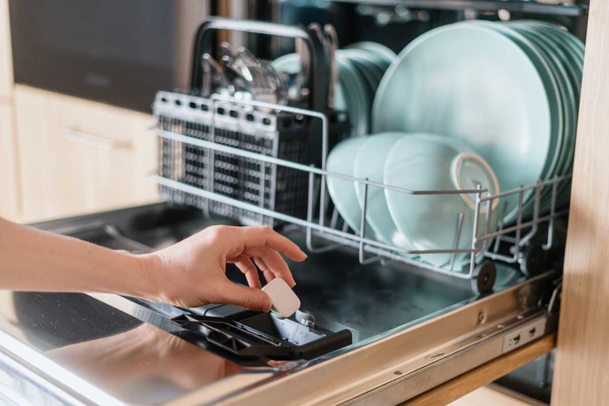 De tablet met afwasmiddel wordt in een speciaal vakje in de vaatwasser geplaatst